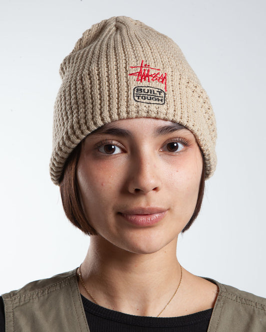 Sand Stüssy beanie, front view, text detail